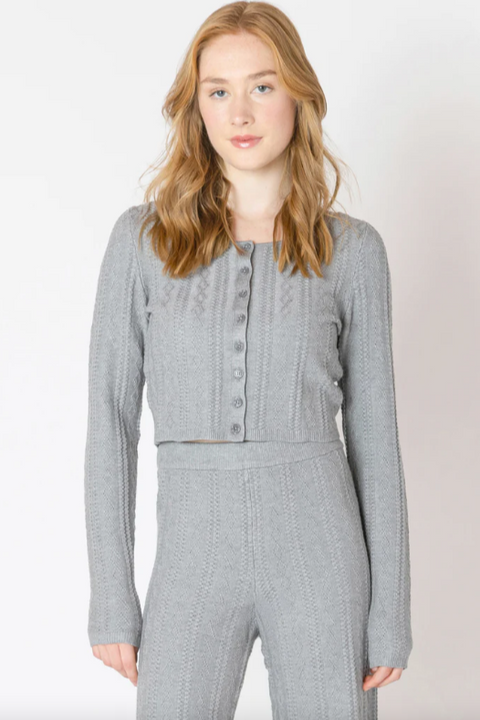 Woman wearing a gray checkered outfit against a white background