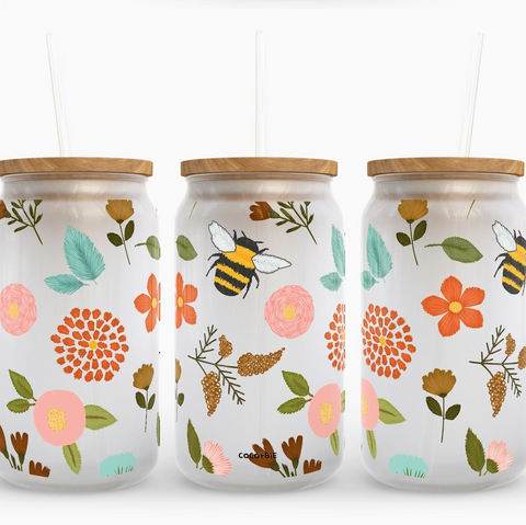 Three glass jars with floral and bee designs on a white background