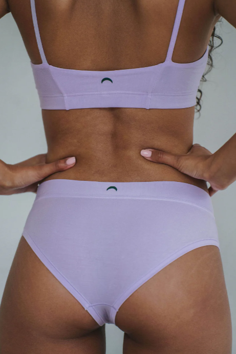 Person wearing a light purple bikini set with a plain background