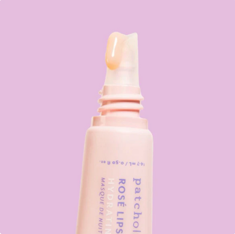 Lip mask bottle with a pink cap on a light purple background