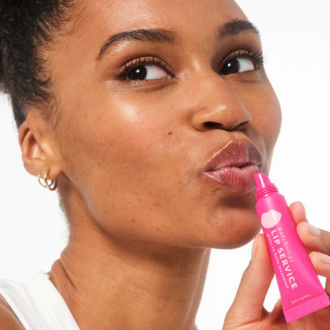 Woman using a pink lip product on a website page with 'Patchology' branding.
