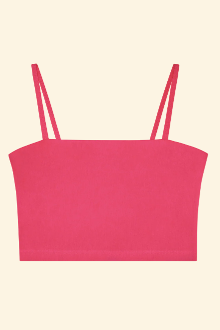 Pink crop top with thin straps on a beige background