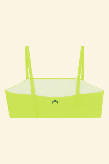 Green bikini top with thin straps on a light green background