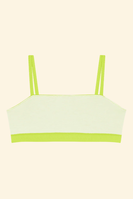 Light green bikini top with thin straps on a beige background