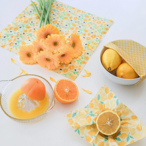 Fruits and a juicer on a table with floral-patterned wrap.