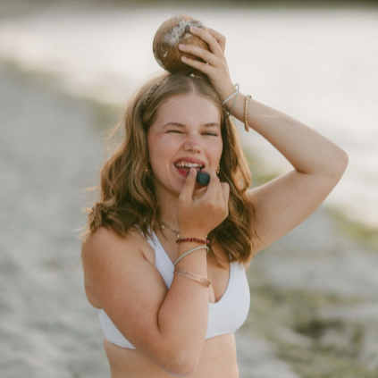Woman applying makeup outdoors by a lake