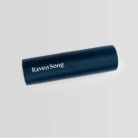 Black cylindrical product with 'Raven Song' branding on a light gray background