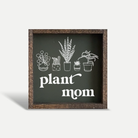 Decorative sign with plant illustrations and 'plant mom' text on a white background