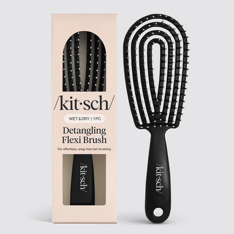 Black detangling flexi brush with packaging on a light gray background