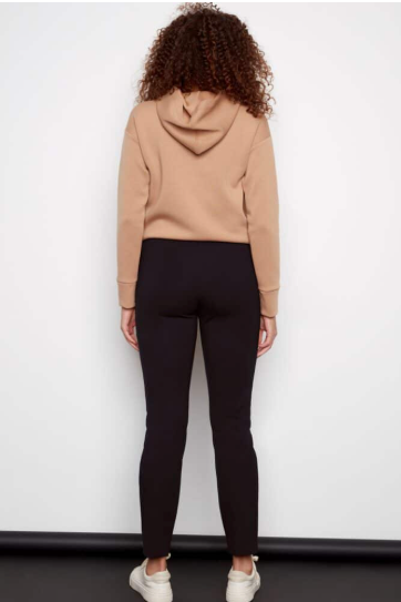 Person wearing a beige hoodie and black pants against a white background