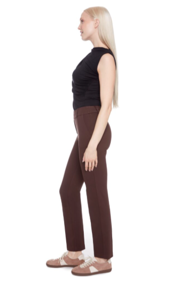Person wearing a black sleeveless top and brown pants on a white background