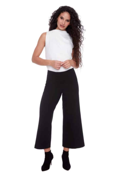 Woman wearing a white top and black high-waisted pants on a white background