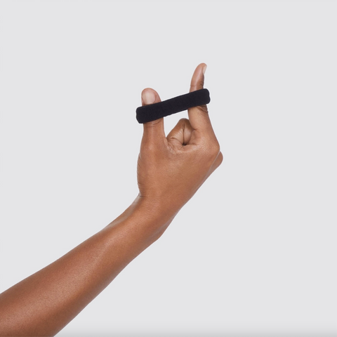 Hand holding a black fitness tracker against a white background
