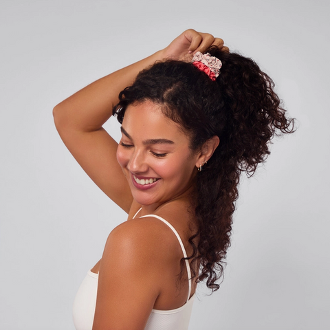 Woman with styled hair against a plain background