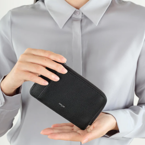 Person holding a black wallet with product details on the right side