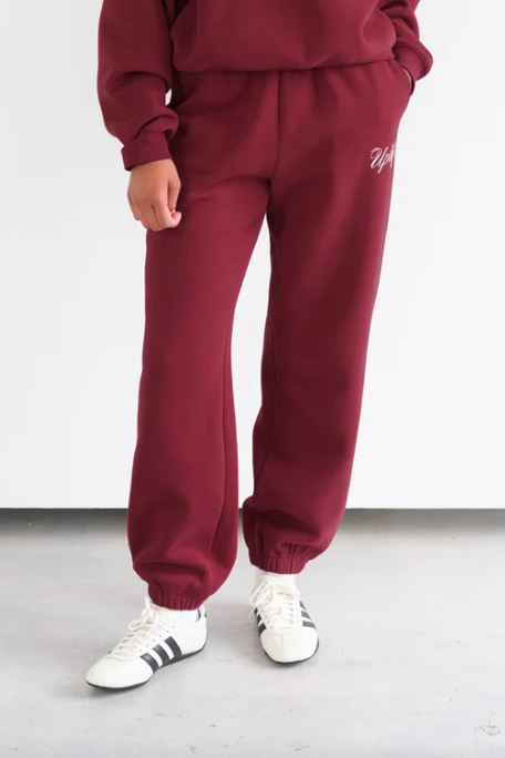 Maroon tracksuit with white text on a plain background