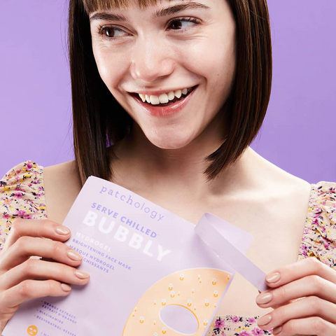 Woman holding a magazine with a purple cover against a purple background