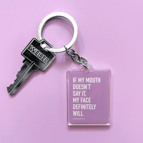 Keychain with a key and a rectangular tag with text on a purple background
