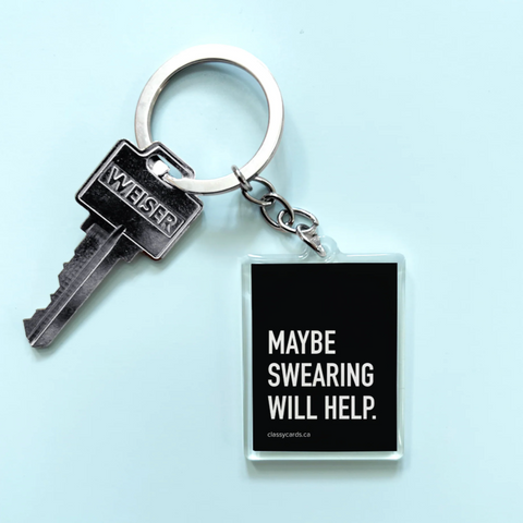Keychain with a key and a square tag displaying 'Maybe Swearing Will Help.' on a light blue background