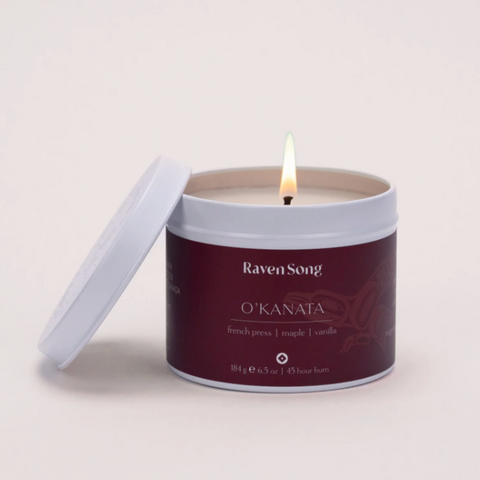 Candle in a branded container on a light gray background