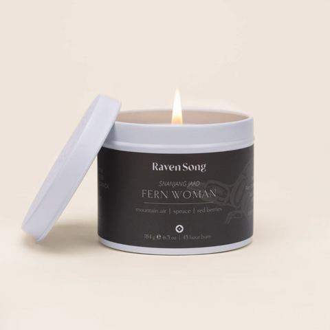 Candle in a tin labeled 'Raven Song' on a beige background