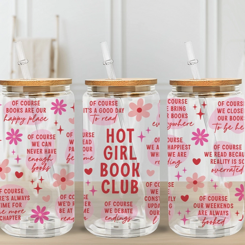 Three glass tumblers with floral and text design on a wooden surface.