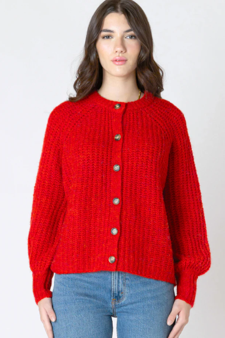 Woman wearing a red knitted cardigan and blue jeans on a white background