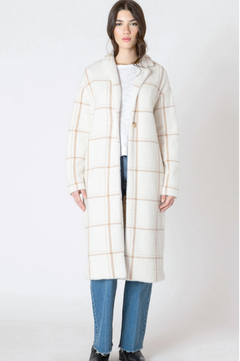 Woman wearing a long plaid coat on a white background