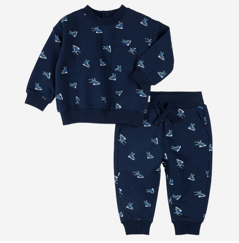 A two-piece kids' outfit set consisting of a navy blue sweatshirt and matching jogger pants, both featuring a repeating pattern of ice skates in shades of blue, white, and light gray.