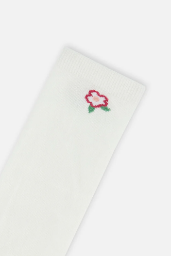 A close-up of a white ribbed sock featuring a small embroidered rose motif in red, pink, and green near the cuff, set against a clean white background.