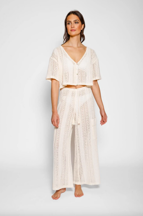 Woman wearing a white lace outfit on a plain background