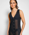 Woman wearing a black sleeveless dress with buttons on a white background