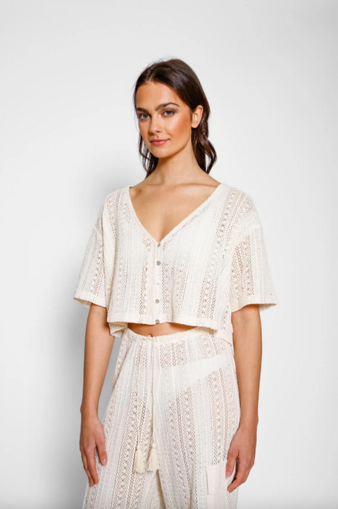 Woman wearing a white lace outfit on a plain background