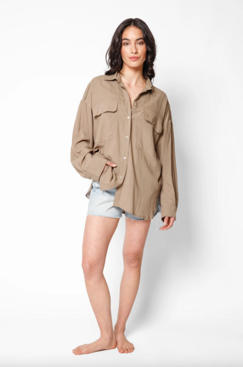 Woman wearing a beige jacket and denim shorts on a white background