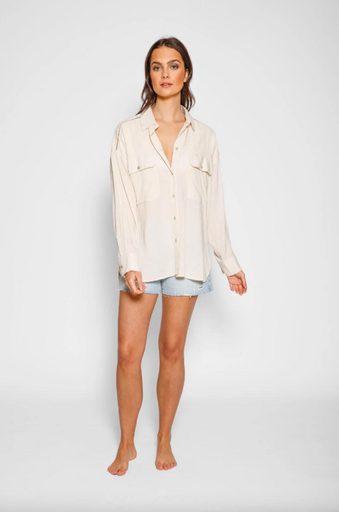 Woman wearing a light-colored shirt and shorts on a white background