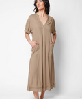 Woman wearing a beige dress against a white background