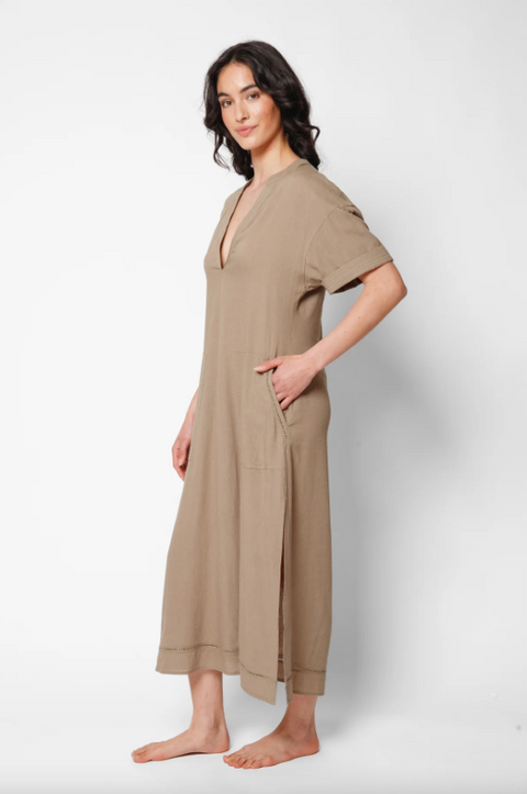 Woman wearing a beige jumpsuit on a white background