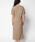 Woman wearing a beige dress against a white background