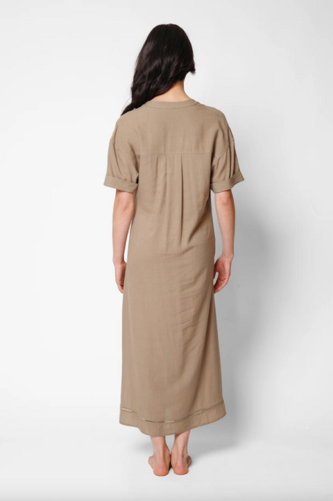 Woman wearing a beige dress against a white background
