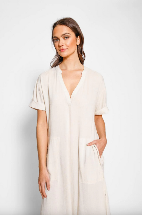 Woman wearing a white dress against a plain background