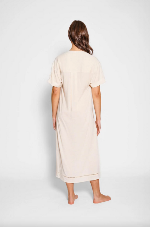 Woman wearing a beige dress against a white background