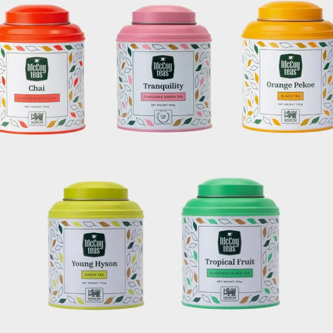 Five tea canisters with colorful lids and labels on a white background