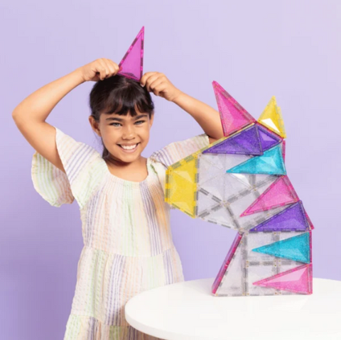 Child playing with colorful geometric building blocks against a purple background