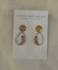 Pair of earrings on a card with 'Olivia's Botanicals' branding on a light background