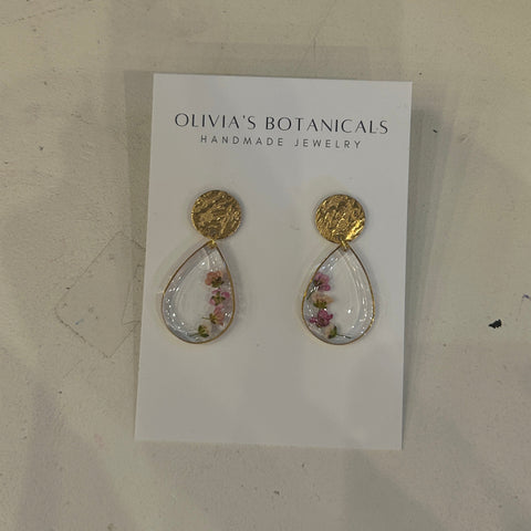 Pair of earrings on a card with 'Olivia's Botanicals' branding on a light background