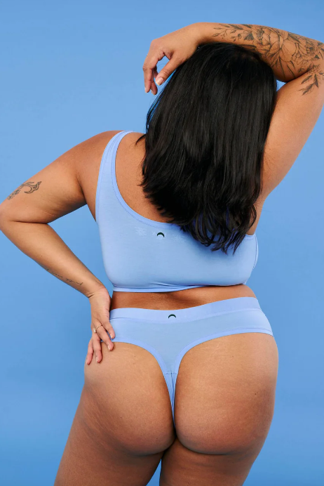 Person wearing a light blue bikini against a solid blue background