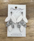 Pair of earrings on a 'Dayna Olson' card with 'Vancouver Island Handmade' text on a wooden surface.