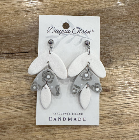Pair of earrings on a 'Dayna Olson' card with 'Vancouver Island Handmade' text on a wooden surface.