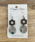 Pair of earrings on a 'Dayna Otson' card with 'Vancouver Island Handmade' text on a wooden surface.