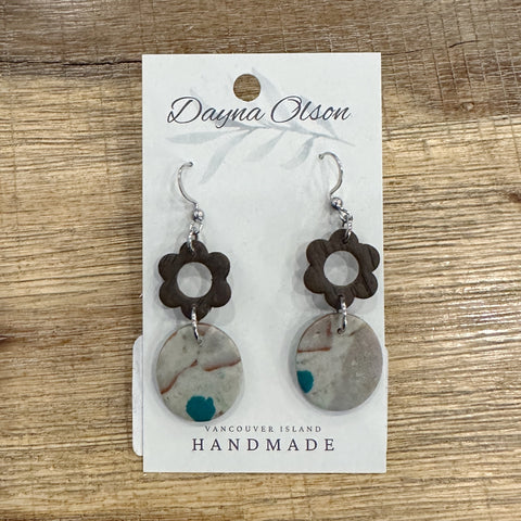 Pair of earrings on a 'Dayna Otson' card with 'Vancouver Island Handmade' text on a wooden surface.